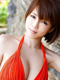 Japanese Yumiko Shaku in orange bath suit takes a walk on the beach